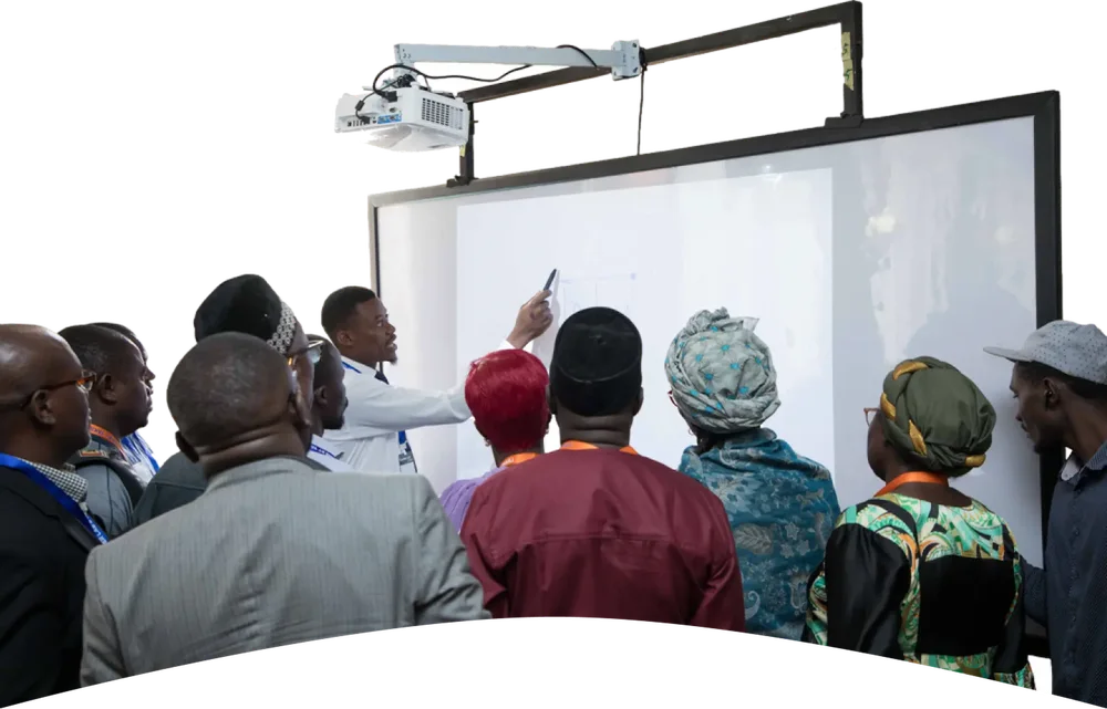 A YAKILI trainer demonstrating an interactive smart whiteboard to a group of educators